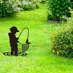 a silhouette of a man holding a fishing net on top of a green grass covered field