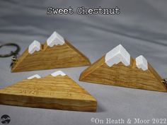 three wooden mountain shaped key chains on a white background with the words sweet chestnut written below them