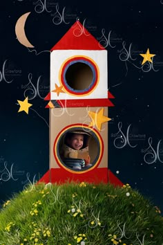 a child's photo in a cardboard house with stars and moon on the night sky