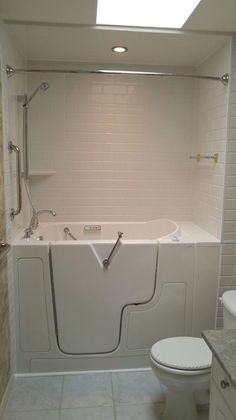 a bathroom with a toilet, bathtub and shower stall in it's corner