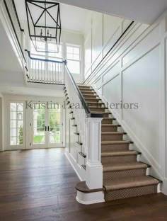 a staircase leading up to the second floor in a house with white walls and wood floors