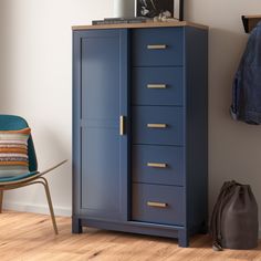 a blue armoire next to a chair in a room with white walls and wooden floors