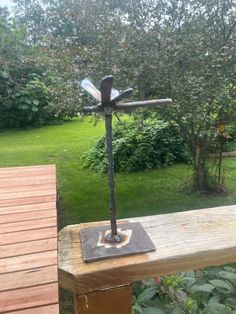 a metal cross sitting on top of a wooden bench