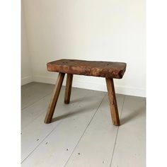 a wooden bench sitting on top of a white floor