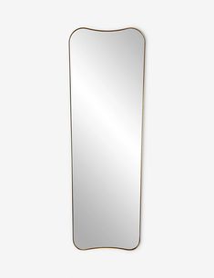 a large rectangular mirror sitting on top of a white wall