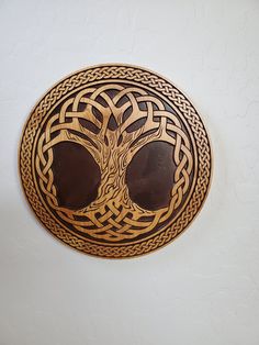 a decorative wooden plate with a tree on the center and two circles in the middle