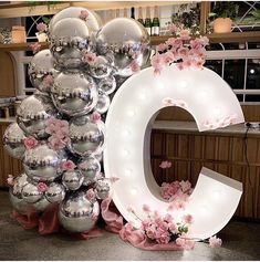 a large number made out of shiny silver balls with pink flowers on the top and bottom