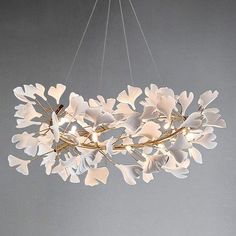 a chandelier with white flowers hanging from it's center and two lights on each end