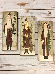 three christmas cards with santa claus, pine cone tree and other decorations on top of white wood planks