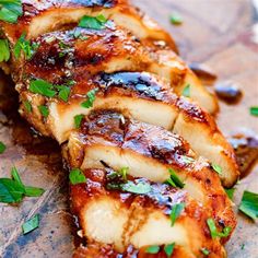 some meat is sitting on a cutting board with parsley sprinkled around it