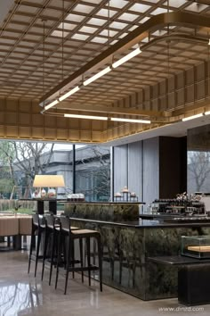 the interior of a modern restaurant with marble counter tops and bar stools in front of large windows