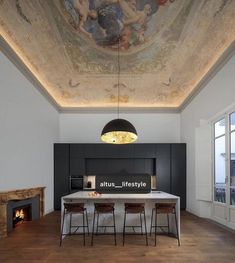 a dining room with a painting on the ceiling