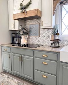 a kitchen with white cabinets and gray counter tops, gold pulls on the cabinet doors