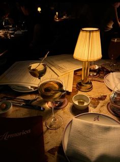 a table topped with plates and bowls next to a lamp on top of a table