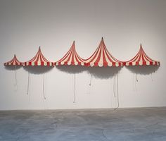 a row of red and white striped tents hanging from the ceiling in an empty room