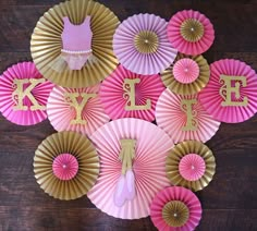 pink and gold paper fans with the letter k on them are arranged in a circle