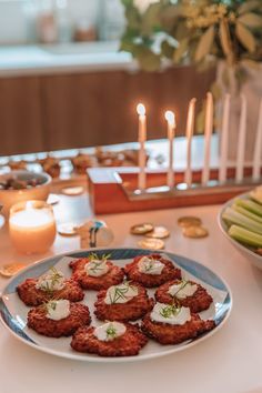 a white plate topped with meat patties covered in sauce and garnished with herbs