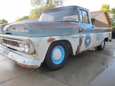 an old truck is parked in a driveway