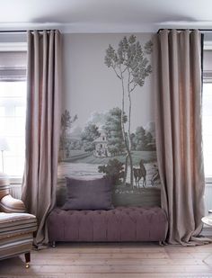 a living room with a couch, window and painting on the wall behind it's curtains