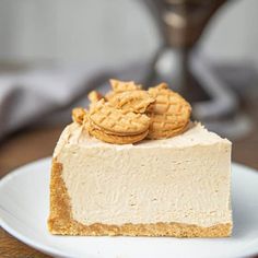 a piece of cheesecake on a white plate with two crackers in the middle