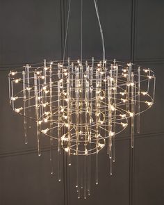 a large chandelier with lights hanging from it's sides and circular rods