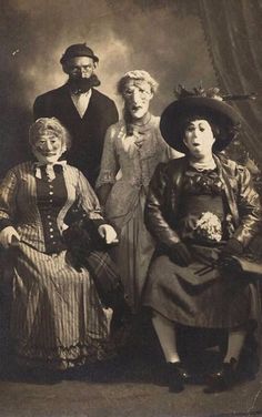 an old black and white photo of four people posing for a family portrait in victorian dress