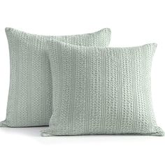 two light green pillows sitting next to each other