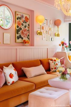 a living room filled with lots of furniture and flowers on the wall next to a window