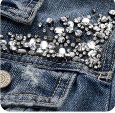 the back pocket of a pair of blue jeans with lots of silver stones on it