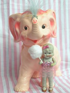 an elephant figurine with a girl holding a lollipop