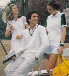 two women and a man holding tennis racquets