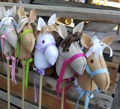 a group of stuffed horses hanging from the side of a wooden fence next to each other