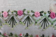 a close up of a piece of fabric with flowers on it and beads around the edges