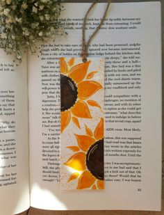 an open book with a sunflower on it