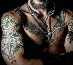 a shirtless man with tattoos on his chest