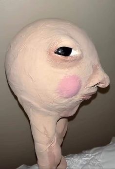 an odd looking white object with pink spots on it's face