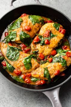 chicken with tomatoes and spinach in a skillet