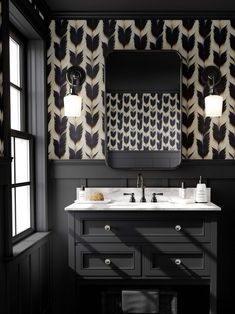 a bathroom with black and white wallpaper, two sinks and a large mirror on the wall