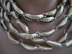 a close up of a necklace on a woman's neck with metal chains attached to it