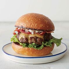 a hamburger on a plate with lettuce and tomato