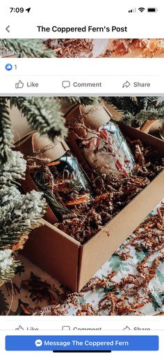 a box filled with lots of different items on top of a bed next to a christmas tree