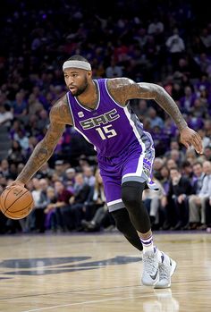 a basketball player dribbling the ball down the court with his right hand and one foot