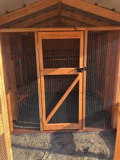 a wooden chicken coop with two doors open