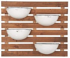 three white bowls mounted to a wooden wall