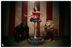 a woman in a costume standing on top of a pedestal next to two gorilla statues