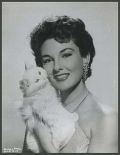 a black and white photo of a woman holding a cat