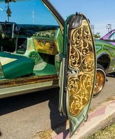 an old car is parked on the side of the road with its door open and it's reflection in the mirror