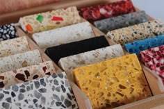 many different colored and patterned items in a wooden box