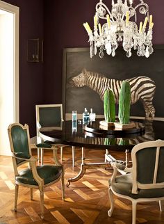 an image of a table with chairs and a zebra painting on the wall