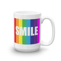 a white coffee mug with the word smile on it in rainbow colors, sitting against a white background